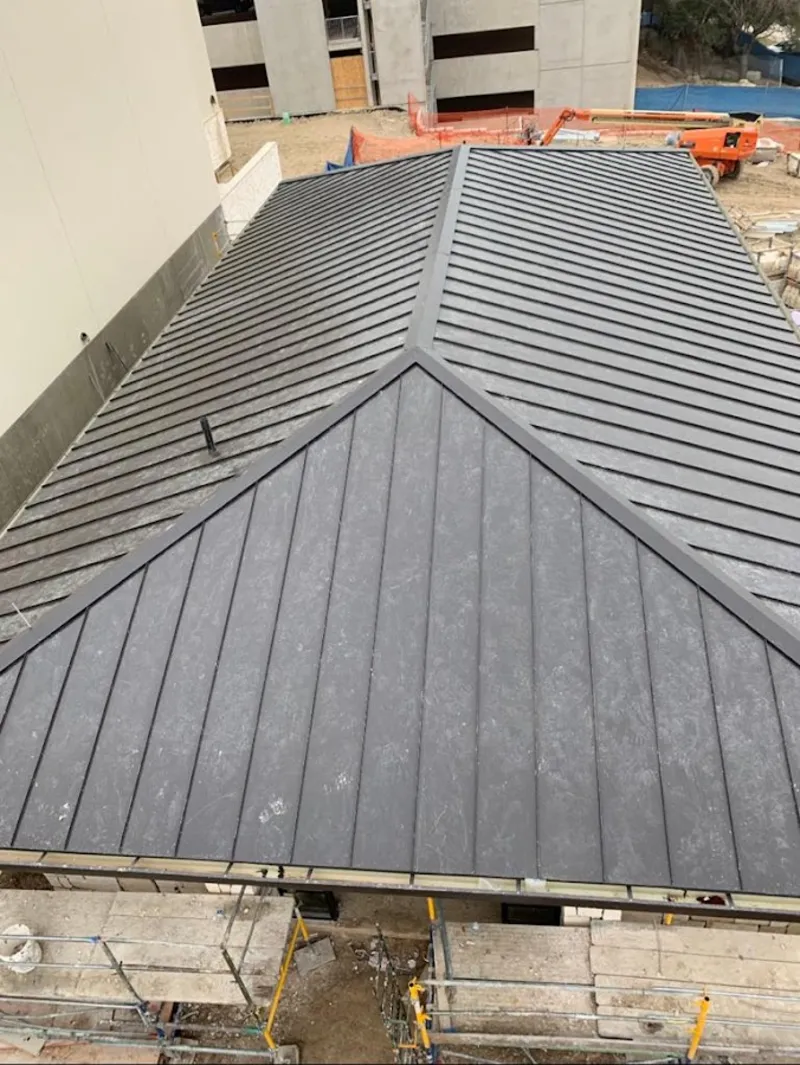 Commercial metal roof construction with crane equipment in Waterville